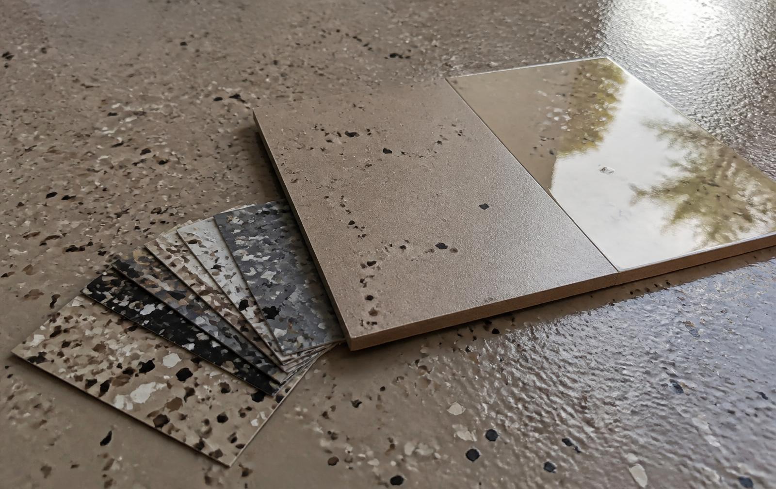 Vinyl flake color chips and satin versus gloss topcoat samples on a finished epoxy garage floor