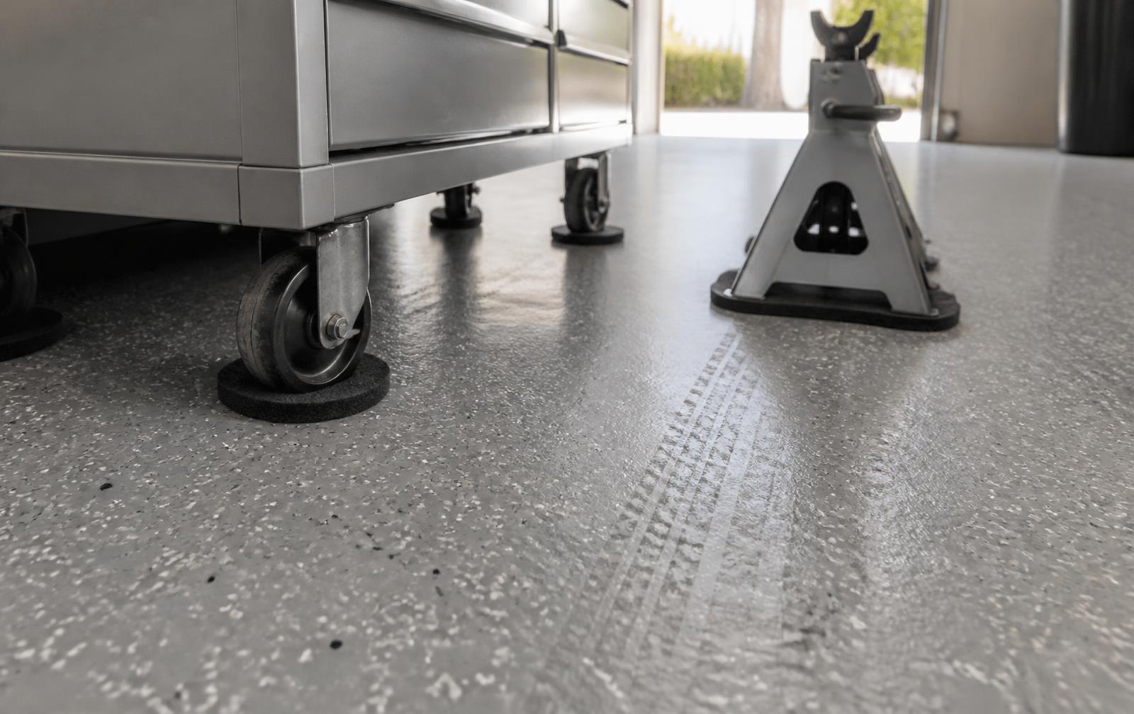 Protective pads under a tool chest and jack stand on a finished flake epoxy garage floor in Garden City